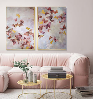 Two of Jackie Von Tobel’s In Flight prints hung side-by-side as a diptych above a pink sofa in an urban chic living room.